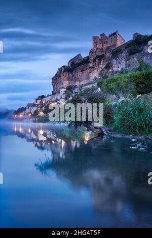 Chateau Beynac before sunrise with village lights reflected in the Dordogne river Beynac Dordogne France Stock Photo