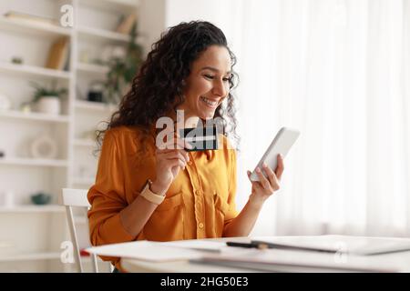 Woman Using Smartphone Shopping Online Holding Credit Card At Home Stock Photo