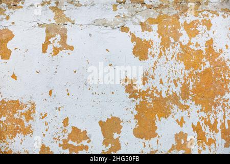 Brown old plaster on the wall with peeling whitewash and cracks. copy space. Stock Photo