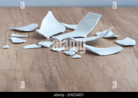 Splinters and Fragments of the broken white ware. Broken Plate, glass.  Pieces of shattered dishes. close-up, side view Stock Photo