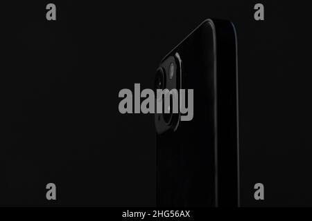 black metal smartphone with rectangular edges and two cameras on a black isolated background Stock Photo