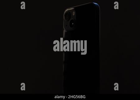 stylish glossy rectangular smartphone with two cameras on a black isolated background close-up. Stock Photo