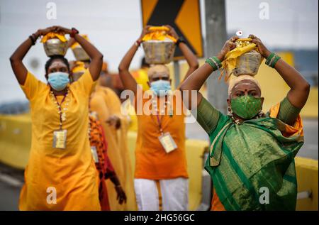 Kuala Lumpur, Malaysia. 18th Jan, 2022. Hindu devotees carry milk pots on their heads in a procession during the Thaipusam festival at the Batu Caves Temple.Thaipusam is an annual Hindu festival celebrated mostly by the Tamil community in honor of the Hindu god Lord Murugan. Devotees will blessings and make vows when their prayers are answered. (Photo by Wong Fok Loy/SOPA Images/Sipa USA) Credit: Sipa USA/Alamy Live News Stock Photo