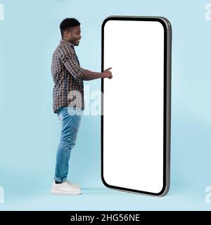 Black guy using white empty smartphone screen panel Stock Photo