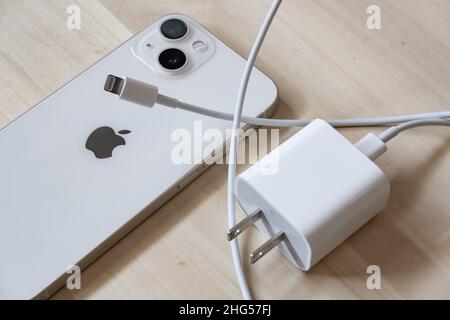 Bangkok, Thailand - January 17, 2022: An iPhone 13 with 20W power adapter and Lightning cable. Stock Photo