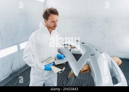 Auto painter works with samples of car paint colors in the automobile painting booth Stock Photo