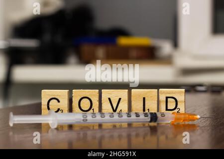 Syringe and inscription covid-19. Covid-19 coronavirus vaccination concept. A new strain of the virus threatens a worldwide epidemic. The progressive Stock Photo