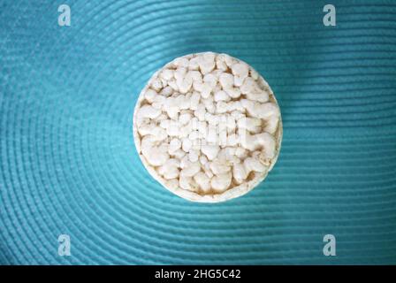 White flat round rice crackers on blue background. Stock Photo