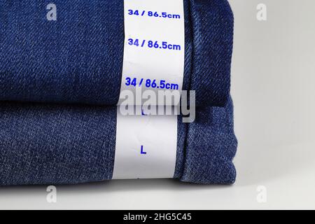 Blue jeans denim with label size, collection jeans stacked with label size, size tag on Blue jeans denim pants. Stock Photo