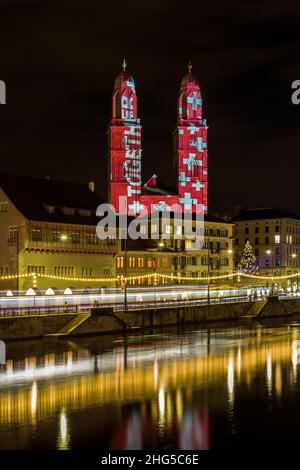 Zurich, Switzerland - 02. January 2022: The new year light show in down town Zurich with Swiss national flag projected on the church Grossmünster with Stock Photo