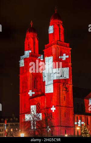 Zurich, Switzerland - 02. January 2022: The new year light show in down town Zurich with Swiss national flag projected on the church Grossmünster. Stock Photo