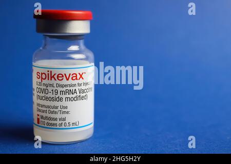 Viersen, Germany - January 9. 2022: Closeup of one isolated mRNA vaccination serum vial Moderna Spikevax , blue background Stock Photo