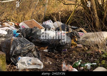 rubbish dumped on waste ground by fly tippers Stock Photo