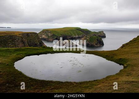 Puddle on a cliff on Mullet Peninsula, view towards Kid Island, County Mayo, Ireland Stock Photo