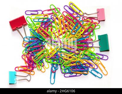 Colorful metal paperclips and pins stationary pile on white background Stock Photo