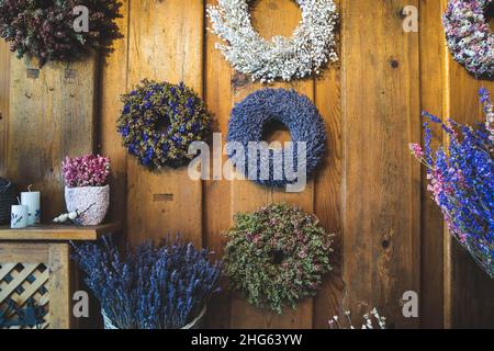Colored spring wreaths of dried flowers at the decoration and flower shop on the wooden background Stock Photo