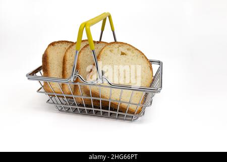 slices wheat bread in steel shopping basket isolated on white background, fresh wheat bread, side view Stock Photo