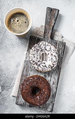 Fresh Chocolate artisan donuts and take away coffee. White background. Top view Stock Photo