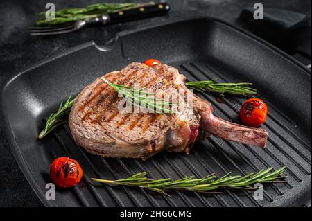 Grilled Tomahawk Rib eye beef (veal) steak on grill pan. Black background. Top view Stock Photo