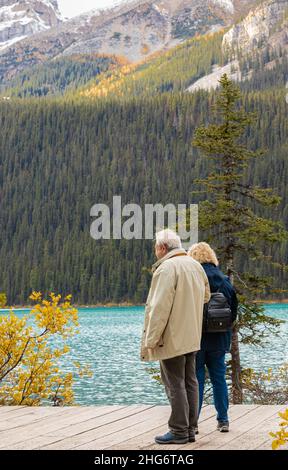 Elderly couple pensioners enjoying the view at Louise Lake in Banff National Park, Canadian Rockies, Alberta, Canada. Travel photo, selective focus-Se Stock Photo