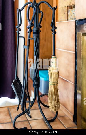 Rustic indoor home interior house cabin fireplace with old retro vintage instruments tools accessories shovel, poker, and broom Stock Photo