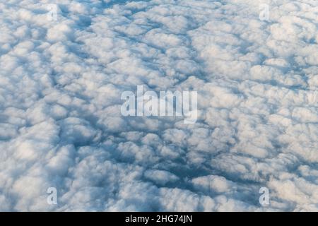 Flying above United Kingdom Scotland with cloudscape aerial high angle view above of abstract dark cloudy landscape sky pattern of white clouds from a Stock Photo