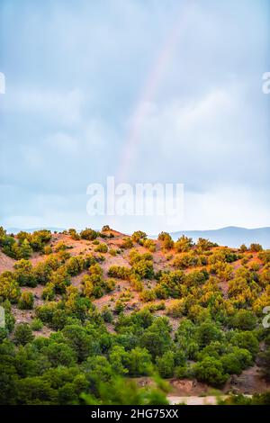 High desert Sangre de Cristo mountain landscape view during summer sunset and colorful rainbow in Santa Fe, New Mexico background vertical view Stock Photo