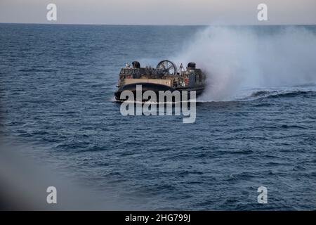 A U.S. Navy landing craft, air cusioned with Assault Craft Unit 4, transport the Ground Combat Element of the 22nd Marine Expeditionary Unit onto amphibious assault ship USS Kearsarge (LHD 3), for Composite Training Unit Exercise (COMPTUEX), Jan. 15, 2022. COMPTUEX is the last at-sea period of the ARG/MEU Predeployment Training Program. COMPTUEX is the final certifying step before the ARG/MEU team to demonstrate its readiness to deploy. (U.S. Marine Corps photo by Cpl. Yvonna Guyette) Stock Photo