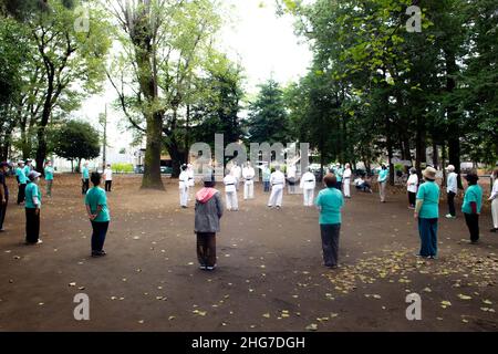 Asian elderly people practicing Tai Chi at public park Stock Photo