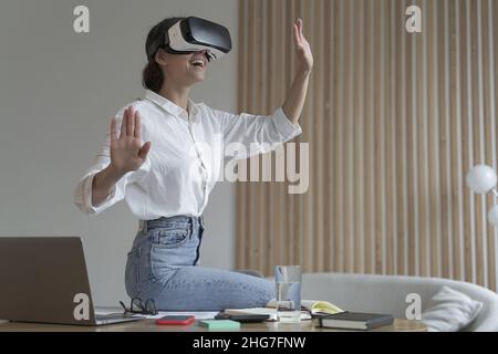 Young amazed businesswoman in virtual reality glasses testing innovative method for business Stock Photo