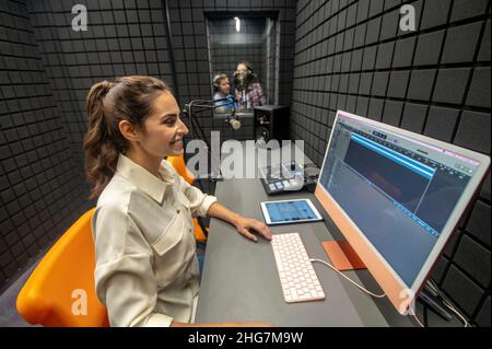 Smiling studio technician monitoring the sound quality Stock Photo