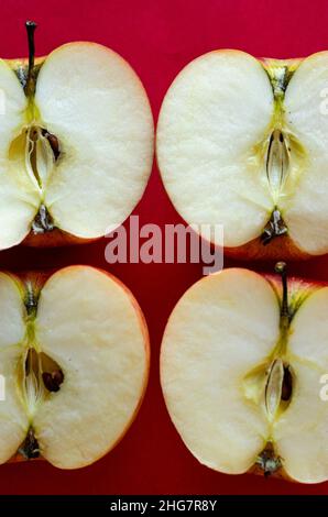half ripe apples on a red background Stock Photo