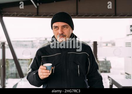 Male  Man drinking Coffee from Paper Cup during winter cold day Stock Photo