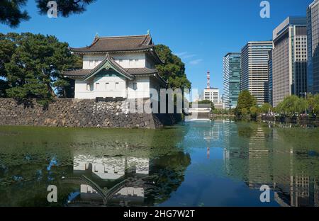 The Kikyo-bori moat around the Tokyo Imperial Palace outer wall with the Edojo Sakurada Tatsumi Yagura guard tower opposite to the modern skyscrapers Stock Photo