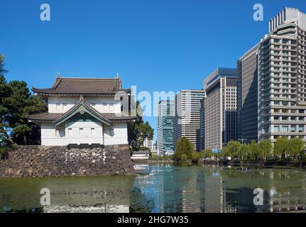 The Kikyo-bori moat around the Tokyo Imperial Palace outer wall with the Edojo Sakurada Tatsumi Yagura guard tower opposite to the modern skyscrapers Stock Photo