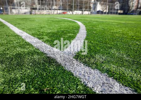 Shallow depth of field (selective focus) details with a synthetic (artificial turf) soccer field. Stock Photo
