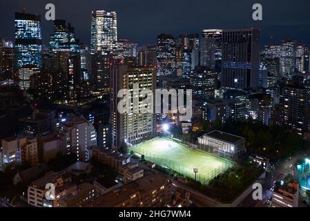 Tokyo, Japan - October 23, 2019: Evening view of Athletic Field at Shiba koen public park in front of Holland Hills Mori tower at skyscrapers center o Stock Photo