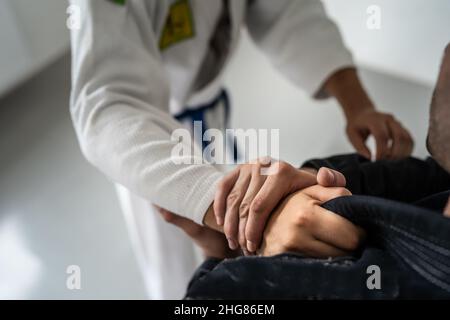 Brazilian Jiu Jitsu BJJ close up on hands and grip on the kimono gi during training or sparing martial arts concept Stock Photo