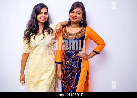 casual indian clothes ,two Indian woman in kurta posing over white wall Stock Photo