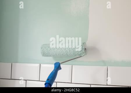 Paint rolle painting on surface wall. Renovation in house Stock Photo