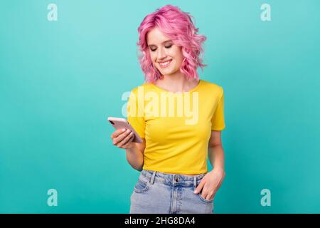 Photo of millennial sweet pink hairdo lady look telephone wear yellow t-shirt isolated on teal background Stock Photo