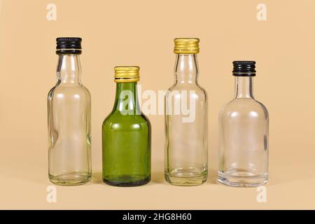 Different empty green and  white glass bottles on beige background Stock Photo