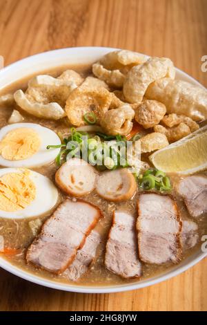 thick egg noodles with fried pork belly or also known as lechon lomi Stock Photo