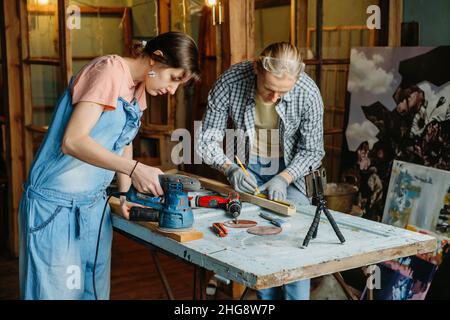 Man and woman working in workshop, doing furniture, reuse old materials to new product. awareness in consumption. Small family business. Recycling Stock Photo