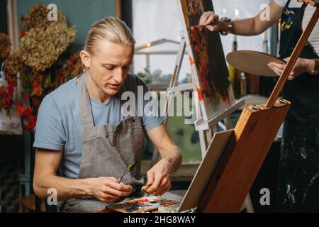 Creative group workshop of painting on big canvas in studio. students painting at art lessons. Art education for adults. Hobby and work  Stock Photo