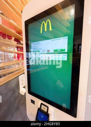 Basel, Switzerland - Dec 20, 2021: new Mcdonald's self order kiosk fast food with POS system printer Stock Photo