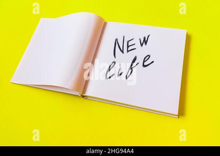 New life. Notepad with blank pages on a yellow background. Stock Photo