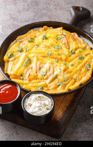 Chipsi mayai or zege is the most popular street food found all over Tanzania is a simple potato egg omelette close up in the plate on the table. Verti Stock Photo