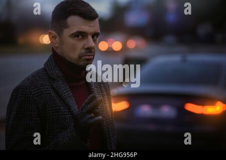Business portrait of a man in front of a car. Stylish and handsome guy in the cityscape. Stock Photo
