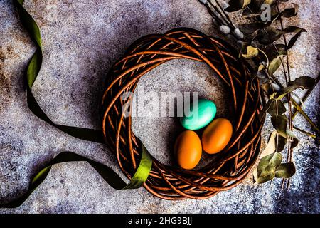 Festive Easter wreath with painted Easter eggs, ribbon and eucalyptus stems Stock Photo